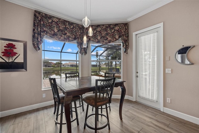 dining space featuring ornamental molding, a sunroom, baseboards, and wood finished floors