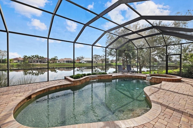 view of pool with glass enclosure, a patio area, a pool with connected hot tub, and a water view