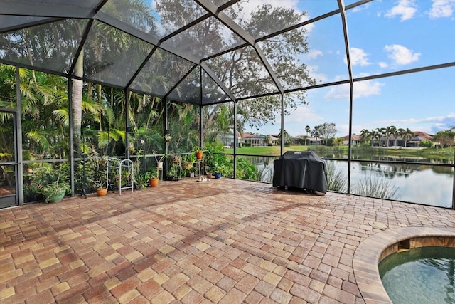 view of patio with a lanai, a water view, and a grill