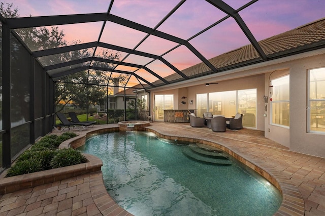 view of pool featuring a pool with connected hot tub, a patio, and a lanai