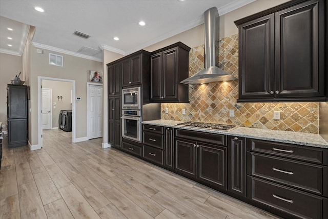 kitchen featuring tasteful backsplash, visible vents, appliances with stainless steel finishes, light stone countertops, and wall chimney exhaust hood