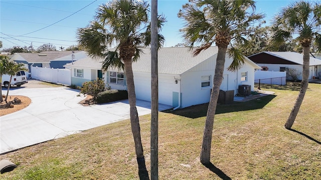 view of side of property with concrete driveway, a lawn, cooling unit, and fence