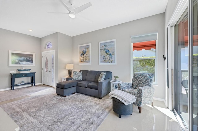 living room featuring baseboards and ceiling fan