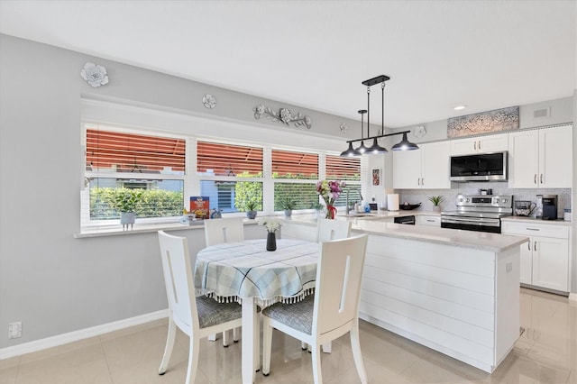 dining area featuring light tile patterned floors, visible vents, and baseboards