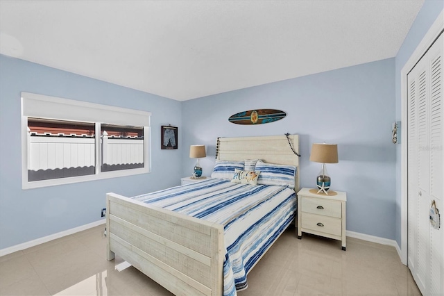 tiled bedroom with baseboards and a closet