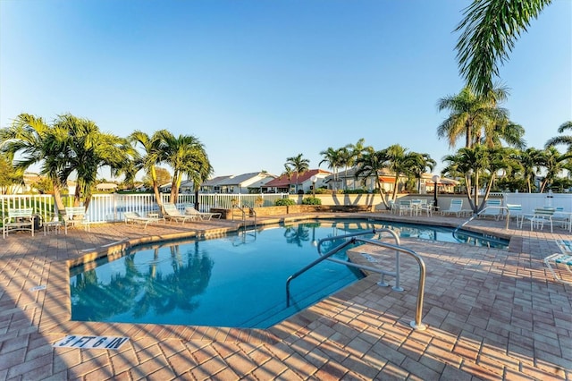 community pool featuring a patio and fence