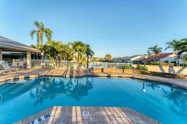 community pool featuring a patio area and fence