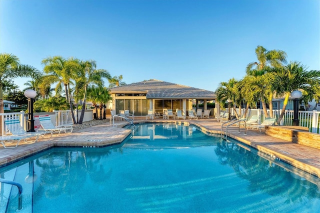 community pool featuring a patio and fence