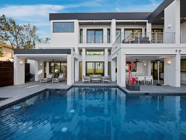 rear view of property featuring a patio, a balcony, and stucco siding