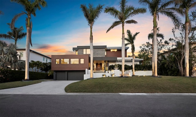 modern home with concrete driveway, a lawn, and an attached garage