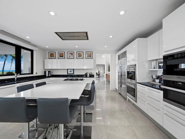 kitchen featuring a kitchen island, modern cabinets, white cabinetry, and a breakfast bar