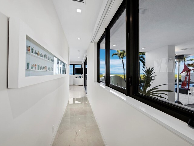 hall featuring marble finish floor and baseboards