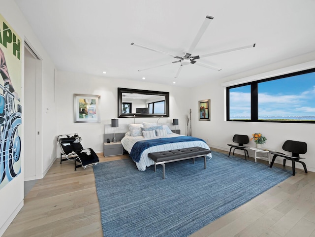 bedroom with baseboards, light wood-type flooring, a ceiling fan, and recessed lighting