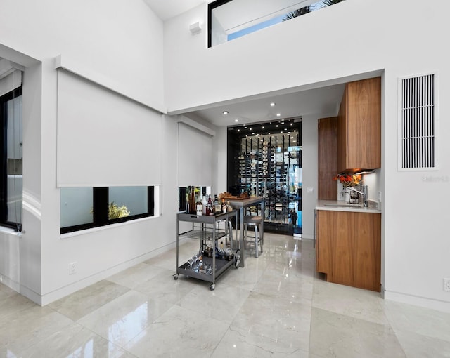 dining area with a towering ceiling, marble finish floor, baseboards, and visible vents