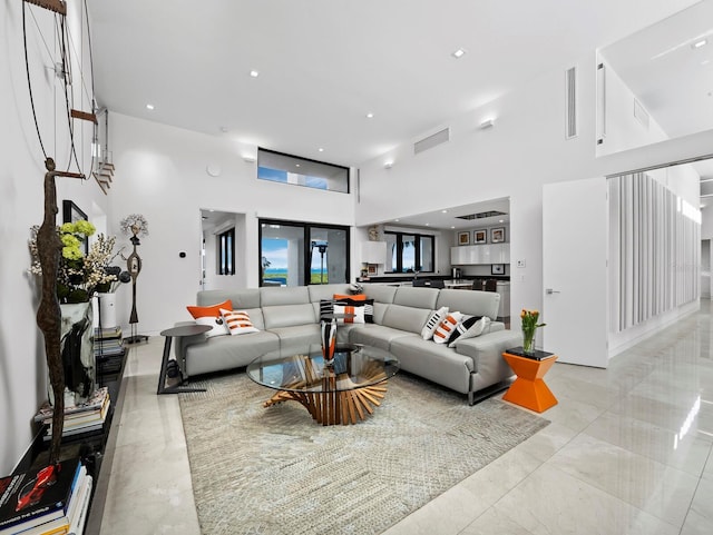 living area featuring a towering ceiling and recessed lighting