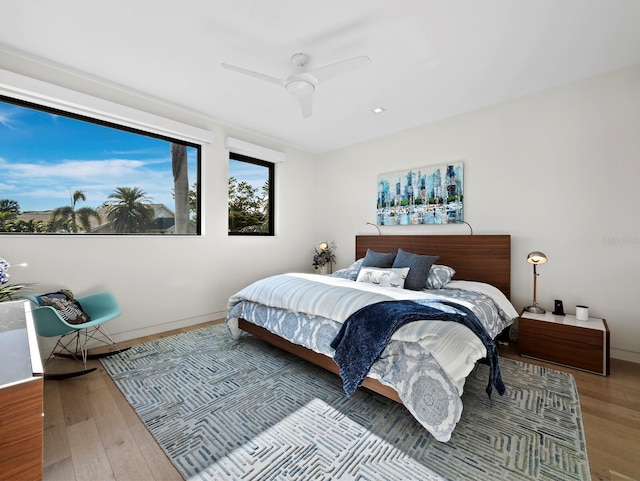 bedroom with ceiling fan, baseboards, and wood finished floors