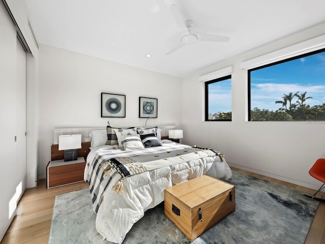 bedroom with baseboards, a closet, a ceiling fan, and wood finished floors