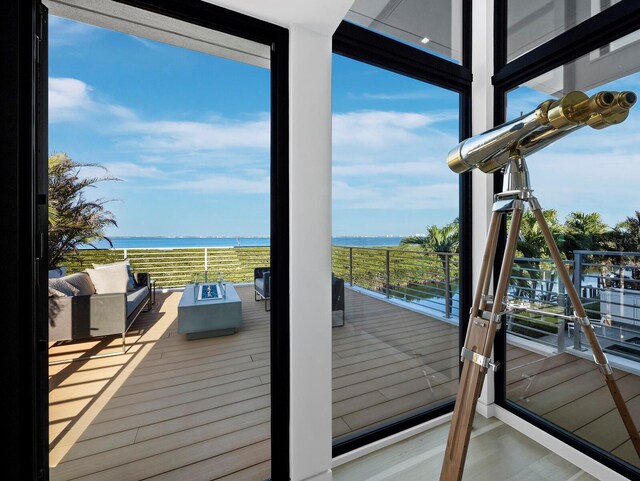 interior space featuring a water view and an outdoor living space with a fire pit