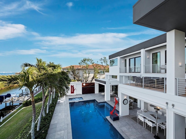 view of swimming pool with a fenced in pool, a water view, a patio, and an in ground hot tub