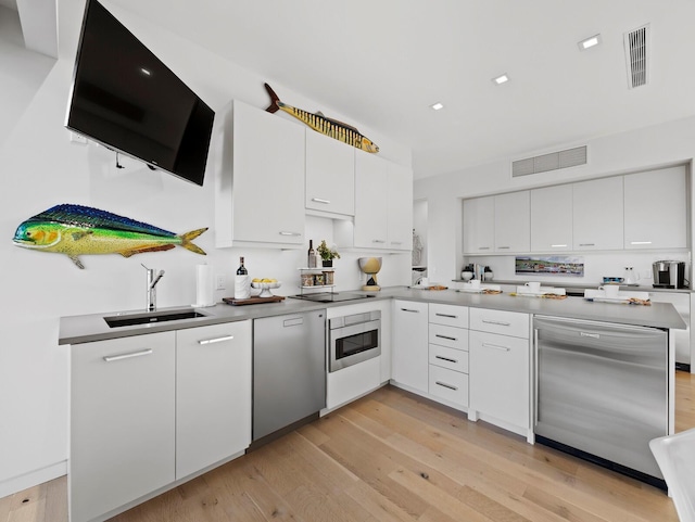 kitchen with visible vents, white cabinets, a sink, dishwashing machine, and black electric cooktop