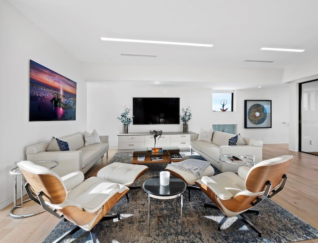 living area with baseboards and wood finished floors