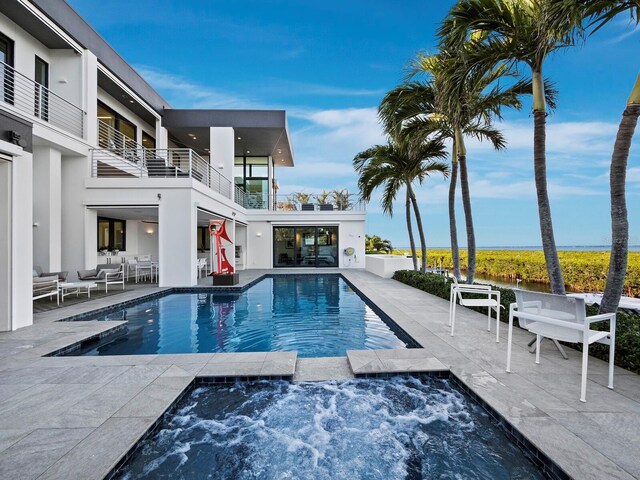 outdoor pool with a patio area, outdoor lounge area, and an in ground hot tub