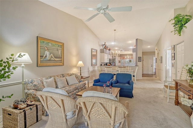 living area featuring ceiling fan with notable chandelier, high vaulted ceiling, and light colored carpet