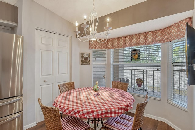 dining area featuring lofted ceiling, an inviting chandelier, baseboards, and wood finished floors