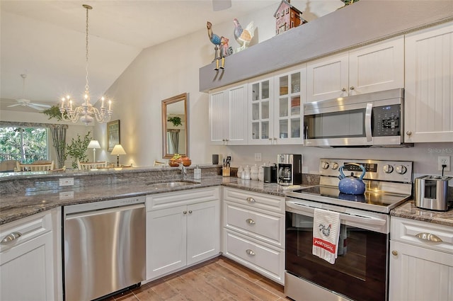 kitchen with stainless steel appliances, white cabinetry, and a sink