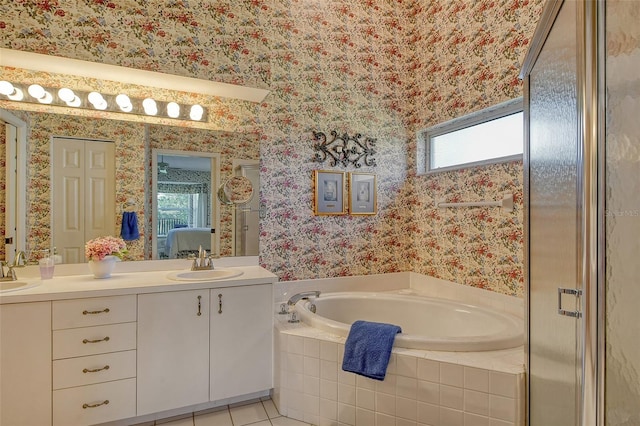 bathroom featuring double vanity, wallpapered walls, tile patterned floors, a garden tub, and a sink