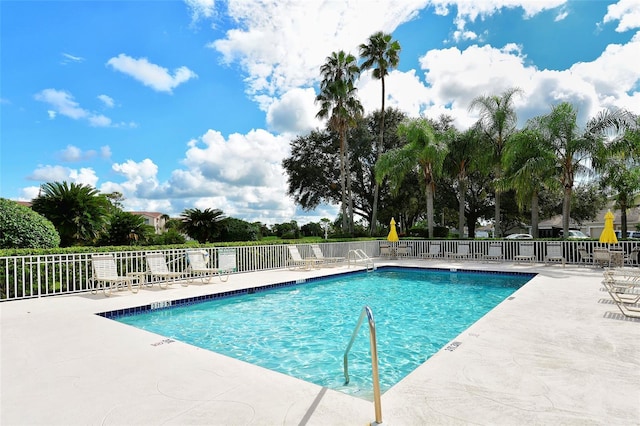 pool with a patio and fence