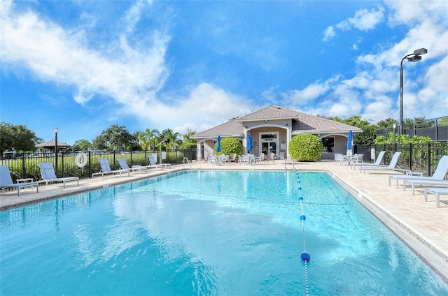 pool with fence and a patio