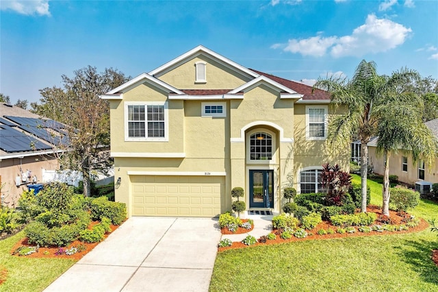 traditional home featuring central air condition unit, a garage, concrete driveway, stucco siding, and a front yard