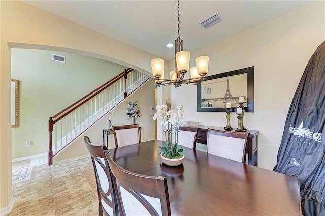 dining area with arched walkways, visible vents, baseboards, and stairs