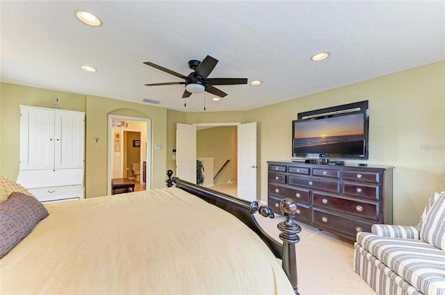 carpeted bedroom featuring ceiling fan, arched walkways, and recessed lighting