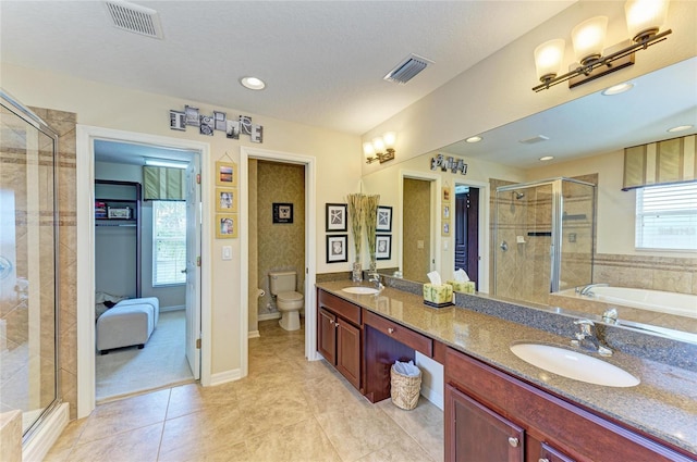 bathroom with a stall shower, a sink, and visible vents