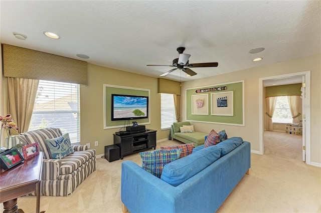 living room with light carpet, a textured ceiling, recessed lighting, and baseboards