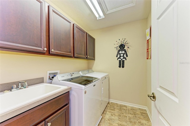 laundry area featuring cabinet space, light tile patterned flooring, a sink, washer and dryer, and baseboards