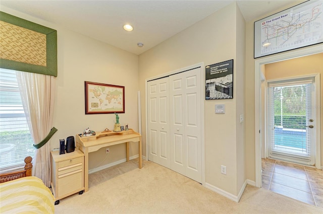 bedroom with light tile patterned floors, recessed lighting, light carpet, baseboards, and a closet