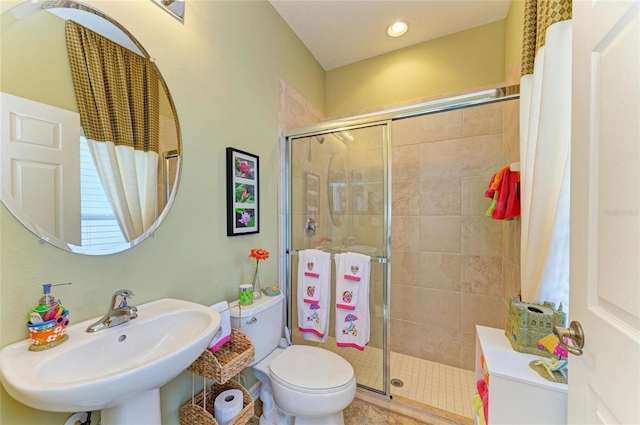 full bathroom featuring toilet, a stall shower, a sink, and recessed lighting