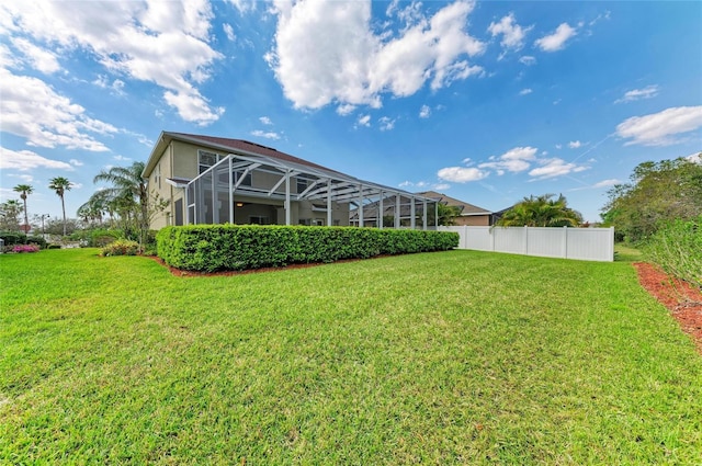 view of yard with glass enclosure and fence