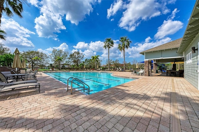 pool with ceiling fan and a patio area