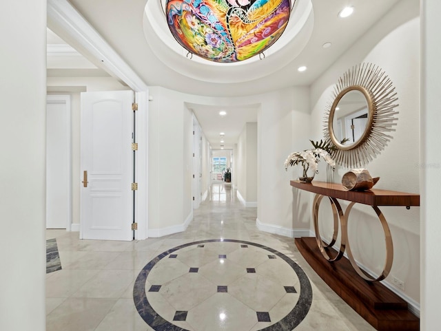 entrance foyer featuring recessed lighting, a tray ceiling, and baseboards