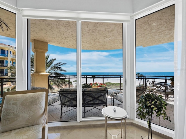 sunroom featuring a water view