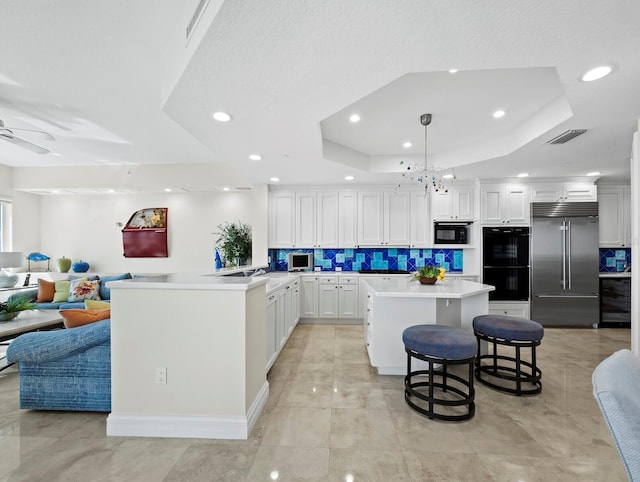 kitchen featuring a tray ceiling, beverage cooler, black appliances, and open floor plan