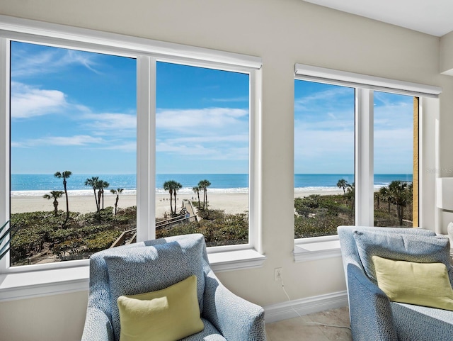 interior space with baseboards, a view of the beach, and a water view