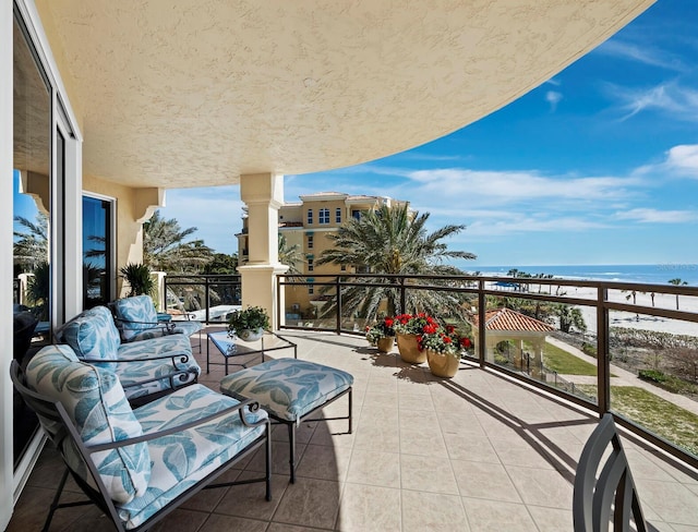 balcony featuring an outdoor living space and a water view