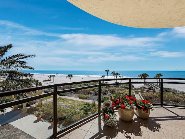 balcony with a water view and a view of the beach