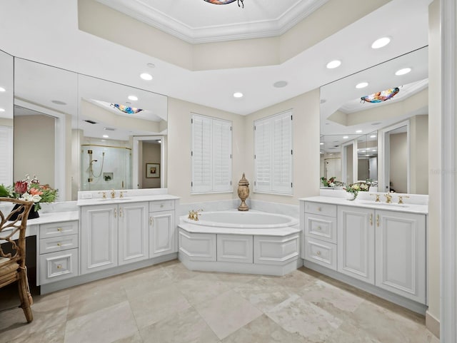 full bath with a garden tub, ornamental molding, a stall shower, a raised ceiling, and a sink