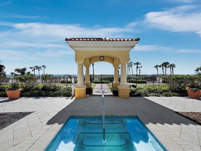 view of swimming pool featuring an in ground hot tub, fence, and a patio area